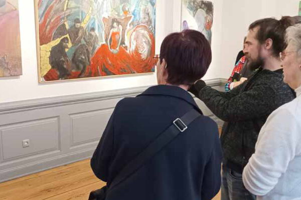 3 Besucher sehen sich Bilder der Galerie an