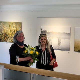 Sabine K. Lauffer überreicht Künstlerin Kerstin Zegenhagen einen Blumenstrauß.