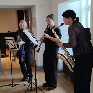 3 dunkel gekleidete Musikerinnen mit Blasinstrumenten