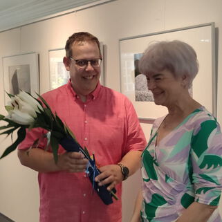 Künstler Steffen Böttcher neben einer Frau in seiner Ausstellung