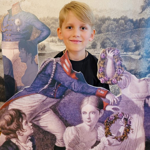 Junge schaut aus einer Fotowand