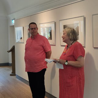Künstler Steffen Böttcher neben einer Frau in seiner Ausstellung