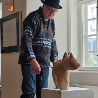 Künstler Peter Hecht neben einer Skulptur von ihm