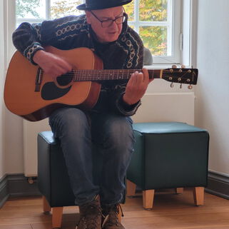 Künstler Peter Hecht mit einer Gitarre
