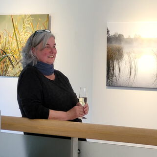 Künstlerin Kerstin Zegenhagen in der Ausstellung mit einem Glas Sekt in der Hand