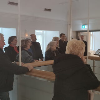 Viele Besucherinnen und Besucher stehen in der Galerie einer Ausstellung