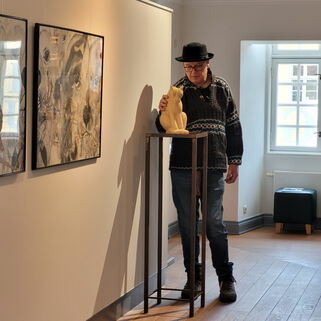 Künstler Peter Hecht neben einer Skulptur von ihm