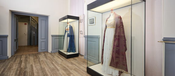 Ausstellungsraum des 3 Königinnen Palais, 2 Vitrinen mit Kleidern von Königinnen
