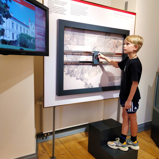 Junge an einer interaktiven Wand des Ausstellungsraumes